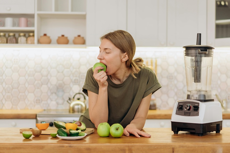 Master Your Metabolism Reviews and What's to Love a Woman Leaning on a Counter Taking a Bite From an Apple