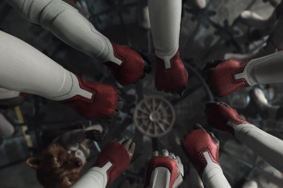 Marvel Movies in Order Close Up of the Avengers in Their Time Jump Suits All Putting Their Fists Together in a Circle