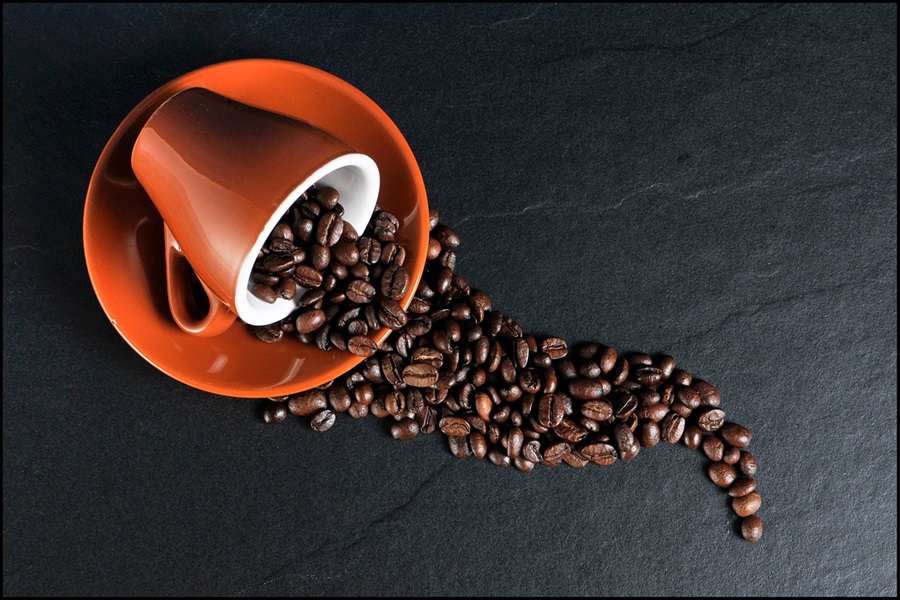 10 April Fools Jokes for Any Age a Coffee Cup Spilt Over with Coffee Beans Spilling From Inside
