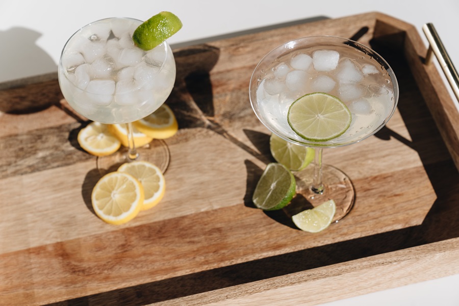 Margarita Recipes to Enjoy Two Margaritas on a Wooden Serving Platter with Lime and Lemon Slices