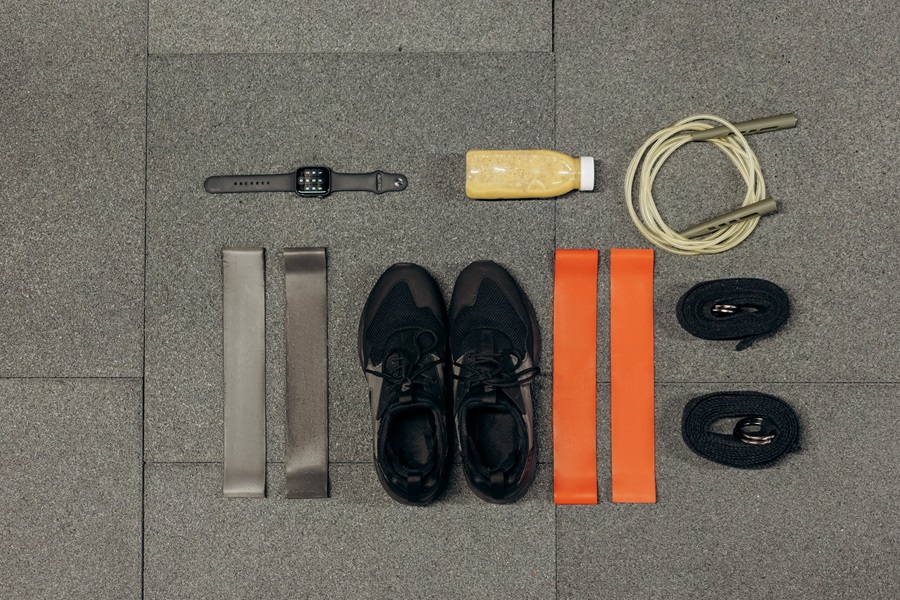 Morning Meltdown 100 Tips and Tricks Close Up of Workout Gear on a Floor Including Shoes, Bands, Water Bottles, Jump Ropes, and a Fitness Tracker