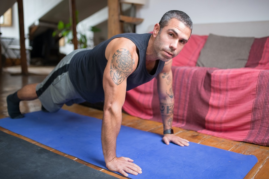 Morning Meltdown 100 Tips and Tricks a Man Doing Planks on a Yoga Mat in a Living Room