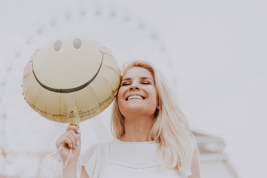Colloidal Silver Uses a Smiling Woman Holding a Happy Face Balloon