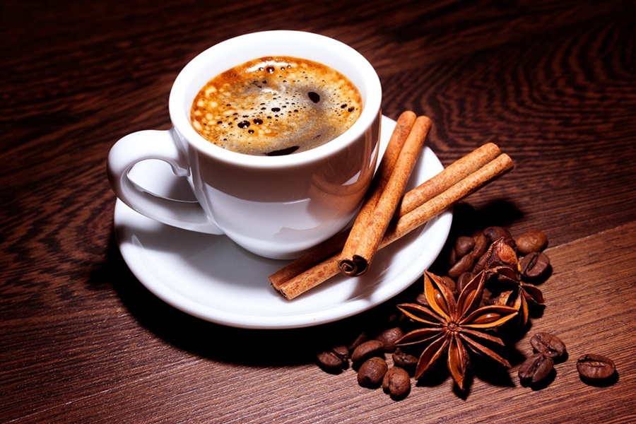 Low Carb Coffee Creamers a Cup of Coffee on a Saucer Next to Two Cinnamon Sticks and a Star Anise