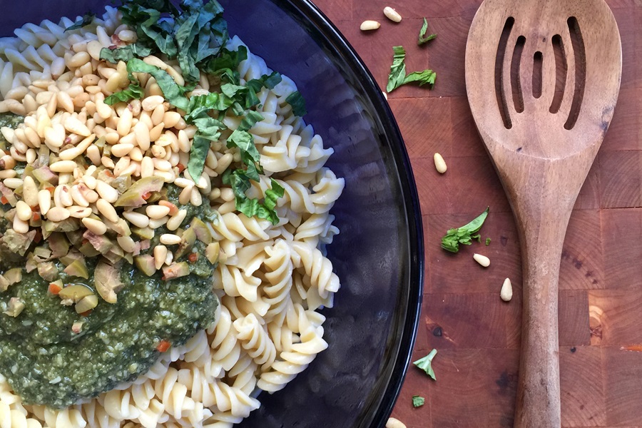 Basil Pesto Pasta Salad Recipe View of Pasta in a Bowl Topped with Chopped Basil and Pine Nuts