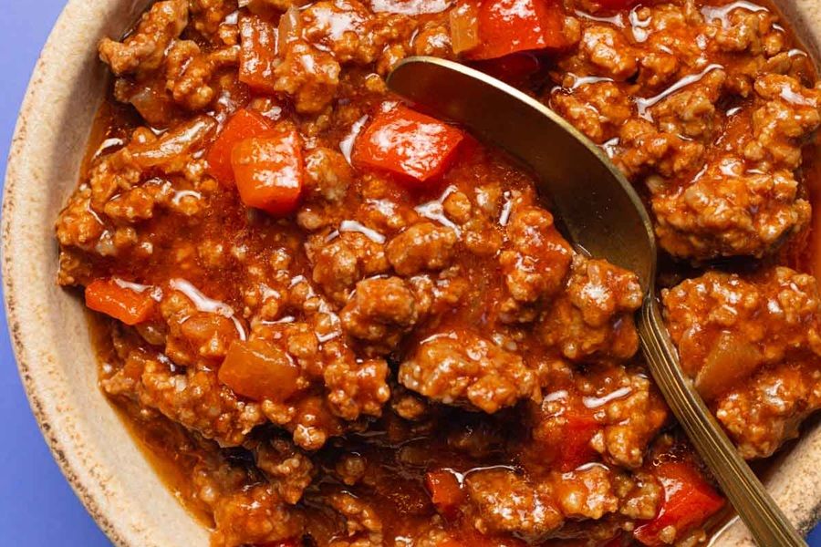 Easy Slow Cooker Sloppy Joes Recipe Close Up of Sloppy Joe Meat Mixture with a Metal Spoon