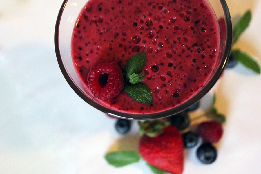 Smoothie Recipes to Reduce Bloating Close Up of a Berry Smoothie Garnished with Fresh Berries