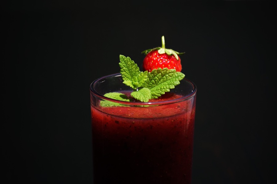 Smoothie Recipes to Reduce Bloating Close Up of a Strawberry Smoothie Topped with a Strawberry