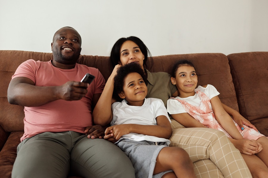 Amazon Fire TV Tips and Tricks a Family with Two Kids Sitting on a Couch Watching TV Together