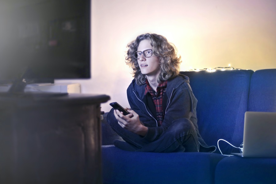 Amazon Fire TV Tips and Tricks a Man Watching TV From His Couch Intently