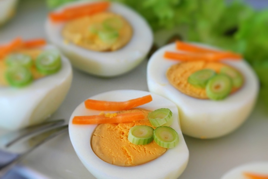 High Protein Low Carb Recipes for Breakfast Close Up of Deviled Eggs Topped with Chives and Carrots