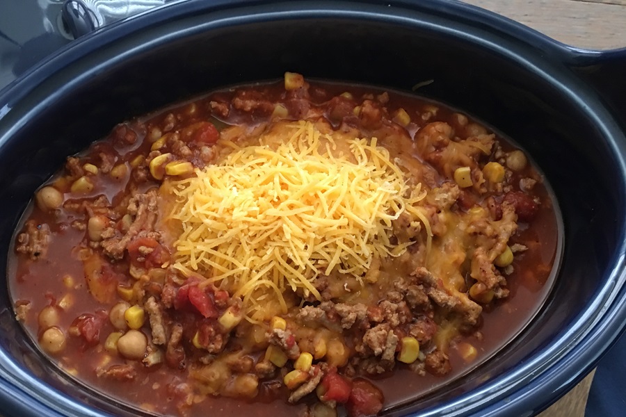 Turkey Chili Crockpot Recipe Close Up of Turkey Chili Topped with Shredded Cheese in a Crockpot