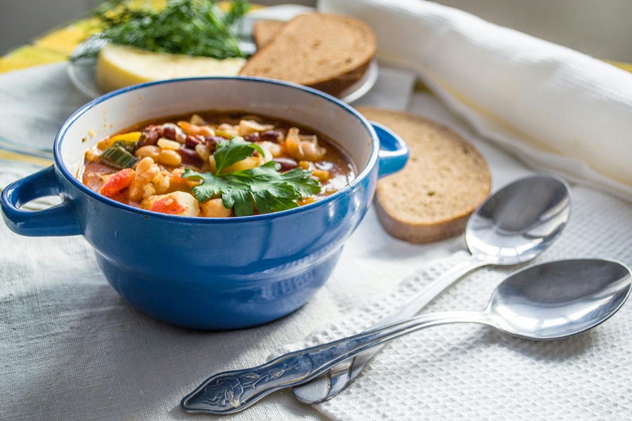 Crock Pot Soups for Fall a Blue Bowl of Hearty Soup with Bread Slices and Spoons