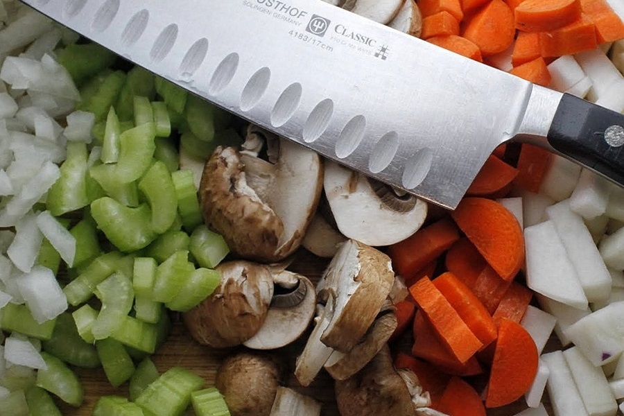 2B Mindset Recipes Close Up of Chopped Veggies with a Knife On Top