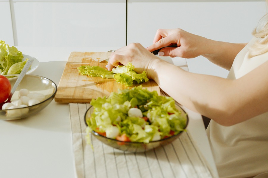 Healthy Copycat Chopped Salad Recipes a Woman Making a Salad at a Table