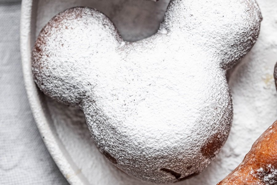 Copycat Disneyland Beignets Recipe Close Up of a Mickey-Shaped Beignet Covered in Powdered Sugar