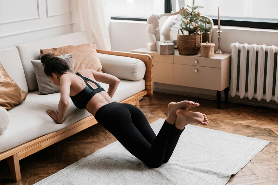 35 At Home Workouts for Women a Woman Doing Pushups Using a Couch in a Living Room