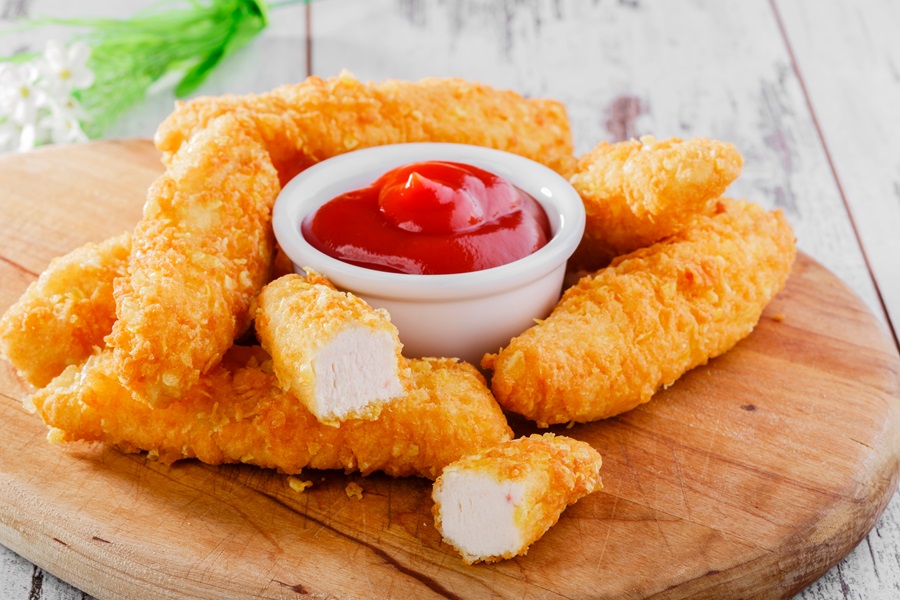 21 Tasty Ketogenic Chicken Strips Recipes a Wooden Cutting Board with Chicken Strips and a Small Bowl of Ketchup