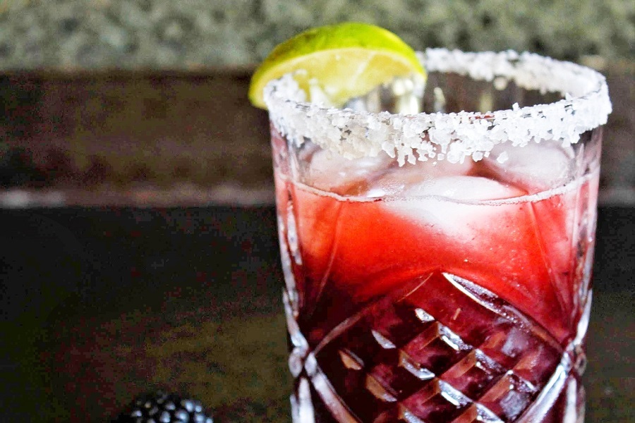 Party Drinks Close Up of a Blackberry Margarita Garnished with a Lime Wedge