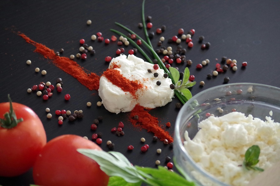 Low Carb Desserts with Cream Cheese a Pile of Cream Cheese with Seasonings and Tomatoes on a Black Surface