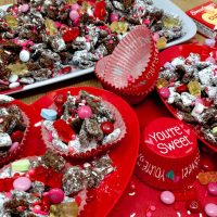 Valentines Puppy Chow Recipe Separated into Small Cupcake Cups That Say "You're Sweet"