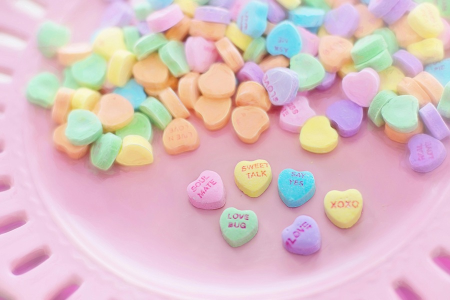 Valentines Puppy Chow Recipe Close Up of Conversation Hearts on a Pink Plate