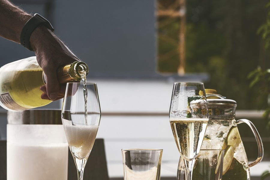 15 Champagne Cocktails to Celebrate Any Occasion a Person Pouring Champagne into Glasses