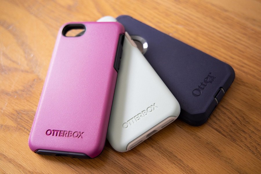 Otterbox Prefix vs Symmetry Three Cases Laid Out on a Wooden Surface