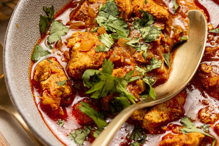 Easy Chicken Tikka Masala Recipe with Coconut Milk Close Up of Chicken in a Dish with a Spoon