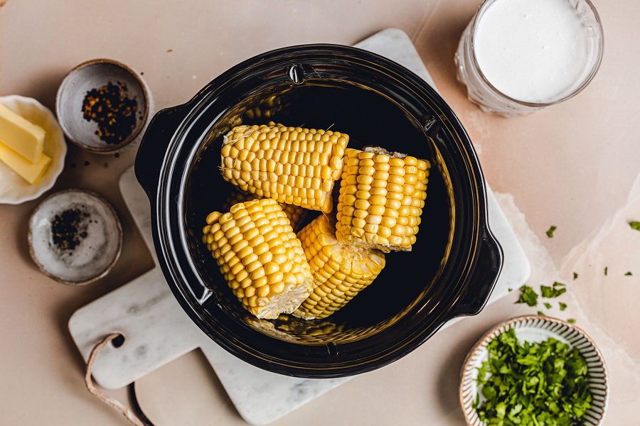 Slow Cooker Corn on the Cob with Coconut Milk Recipe Overhead View of a Crockpot with Corn Halves