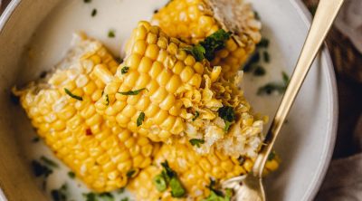 Slow Cooker Corn on the Cob with Coconut Milk Recipe Close Up of Corn on the Cob Halves in a Bowl Sprinkled with Cilantro