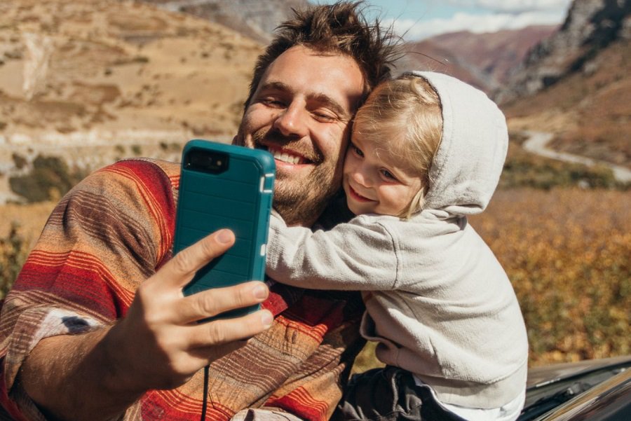 Otterbox Defender vs Commuter vs Symmetry a Man and His Daughter Hugging and Taking a Selfie with a Phone in a Teal Otterbox Case