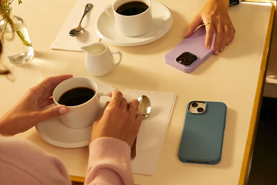 Otterbox Prefix vs Commuter a Two People Sitting at a Table with Cups of Coffee and Two Phones Each in an Otterbox Case
