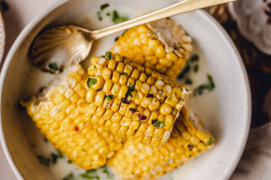 Slow Cooker Corn on the Cob with Coconut Milk Recipe Close Up of Corn on the Cob Halves in a Bowl
