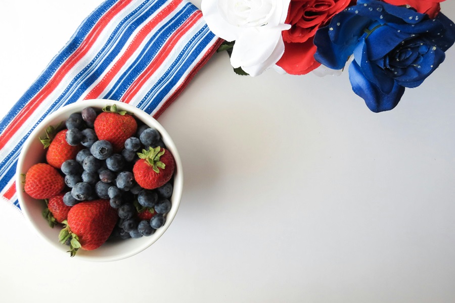 Easy 4th of July Recipes a Bowl of Berries on a Red, White and Blue Striped Towel on a White Surface