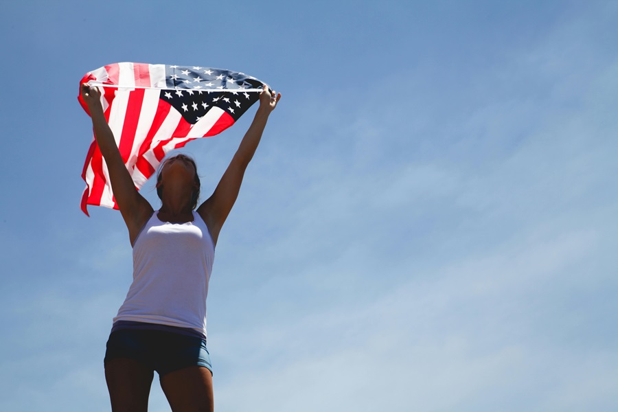 Easy 4th of July Recipes a Woman Standing Outside Holding an American Flag Above Her Head with Both Hands
