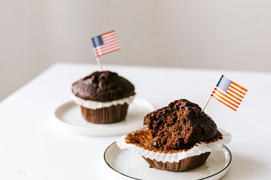 55 Patriotic Dessert Recipes Close Up of Two Chocolate Muffins with American Flag Toothpicks in Each