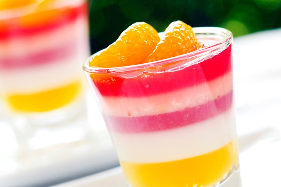 Easy Margarita Jello Shots for Margarita Lovers Close Up of a Jello Shot with Red, White and Yellow Layers Topped with Mandarin Orange Slices