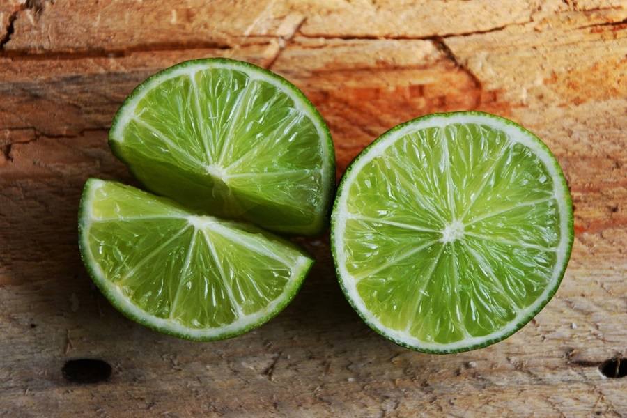 Easy Margarita Recipe Close Up of a Lime Cut in Half on a Wooden Cutting Board