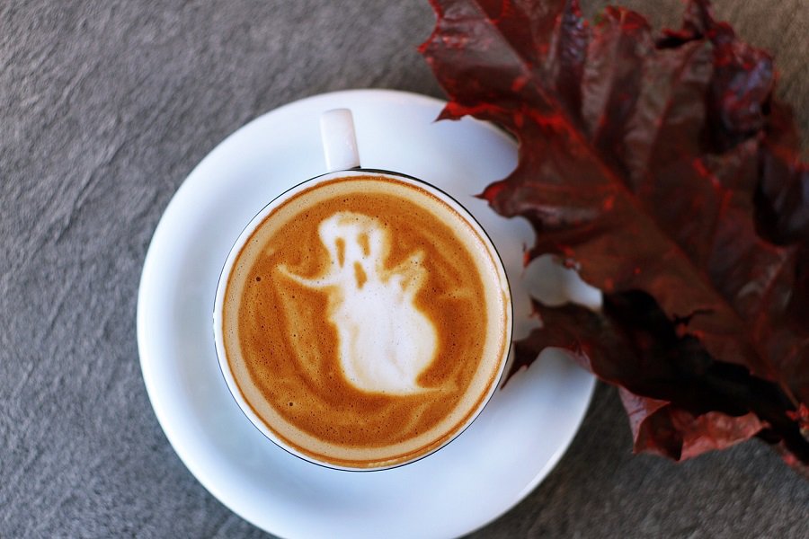 DIY Halloween Decorations Overhead View of a Cup of Espresso with a Ghost Made from Foam on Top