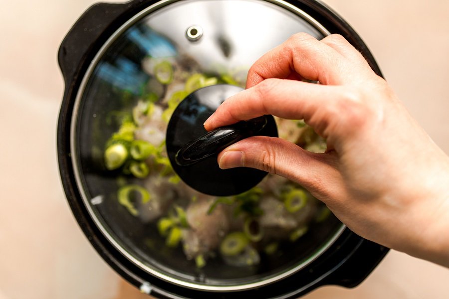 Slow Cooker Chicken Broccoli and Rice Casserole Person's Hand Putting a Lid on a Slow Cooker