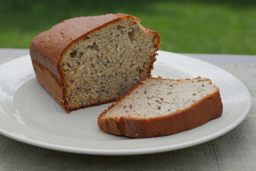 Best Gluten Free Dairy Free Banana Bread Recipes Close Up of a Loaf of Banana Bread with a Slice Cut Out on a White Plate