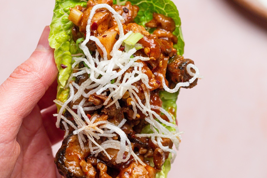 Copycat Pei Wei Chicken Lettuce Wraps Recipe Close Up of a Chicken Lettuce Wrap in a Person's Hand