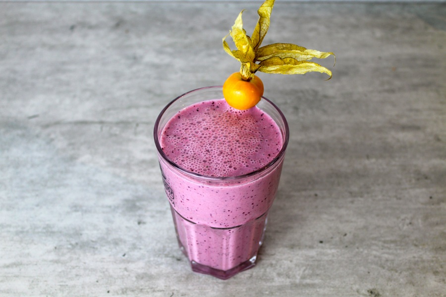 Best Dairy-Free Meal Replacement Shakes a Pink Smoothie on a Counter Garnished with a Small Orange
