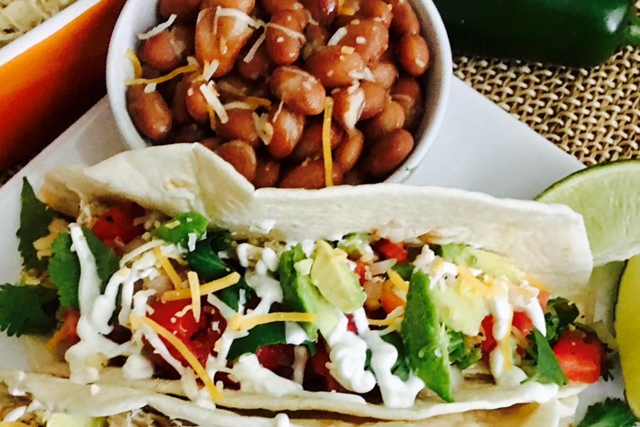 Jillian Michaels Bodyshred Meal Plan Close Up of Shredded Chicken Tacos on a Plate Next to a Bowl of Pinto Beans