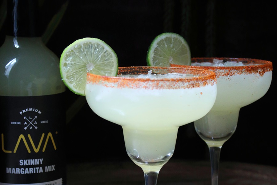 Limeade Margarita Recipe Ideas Close Up of Two Margaritas Garnished with Lime Slices Next to a Bottle of Margarita Mix