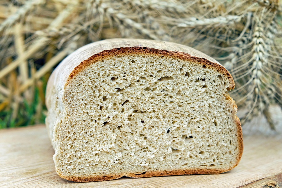 Is Gluten Free Bread Good for Diabetics Close Up of a Sliced Loaf of Bread with Wheat in the Background