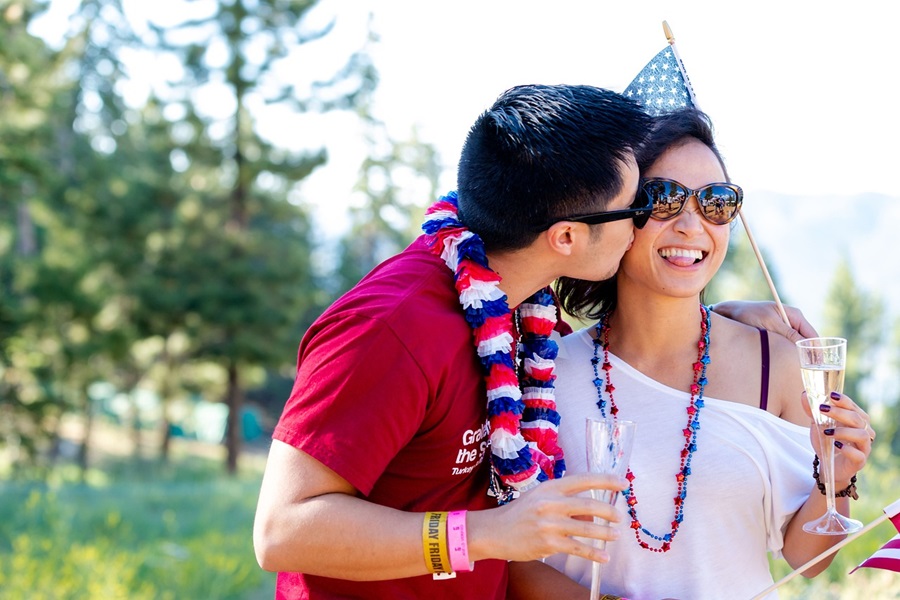 Low Carb Fourth of July Desserts a Man Kissing a Woman on the Cheek Both Wearing Patriotic Colors and Holding American Flags