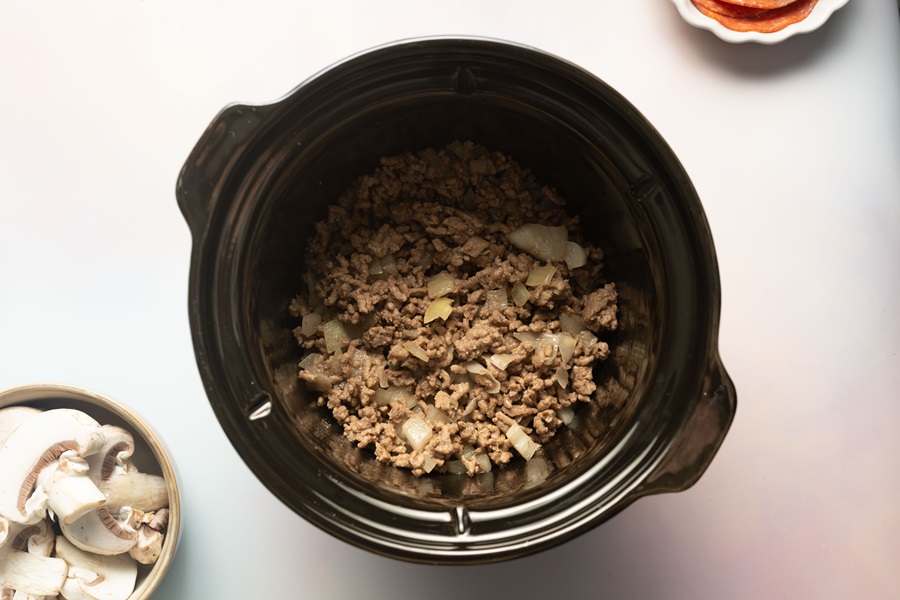 Keto Crockpot Casserole for Pizza Lovers a Layer of Browned Ground Beef in a Crockpot