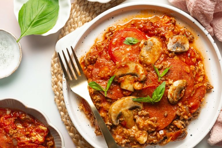 Keto Crockpot Casserole for Pizza Lovers a Plate of Pizza Casserole Topped with Mushrooms, Basil, and Pepperoni